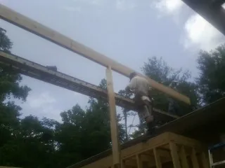 Carpenter setting a ridge beam over a new addition frame — Ice Dam Removal by Roofing Brothers in Pilot Hill
