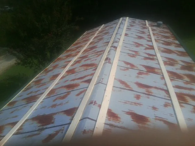 Rusted metal roof panels with new wood purlins before replacement — Storm Damage Roof Repair in Pilot Hill by Roofing Brothers