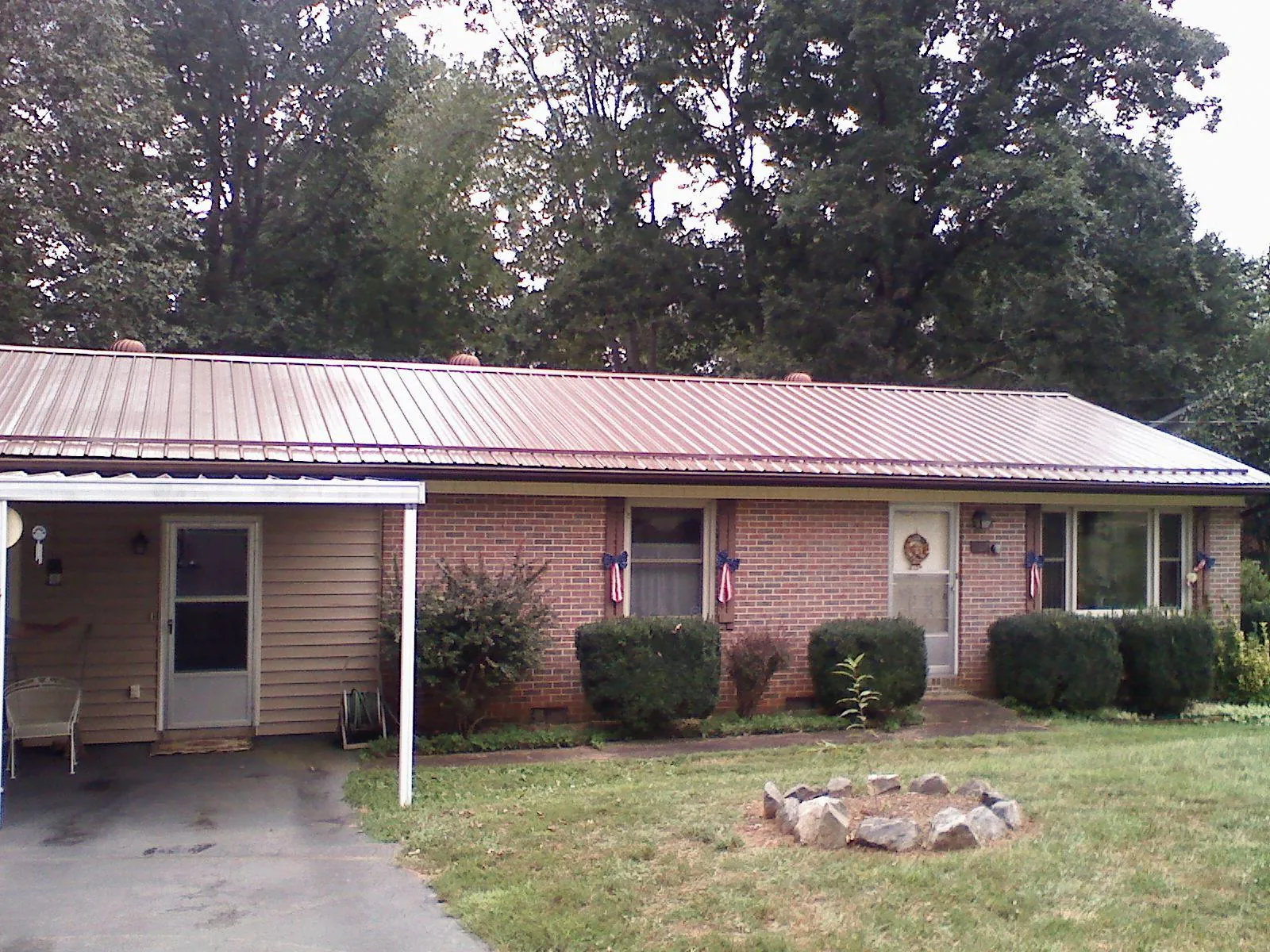 Bronze metal roof and carport on a brick ranch home — Roof Repair work by our crew in Pilot Hill